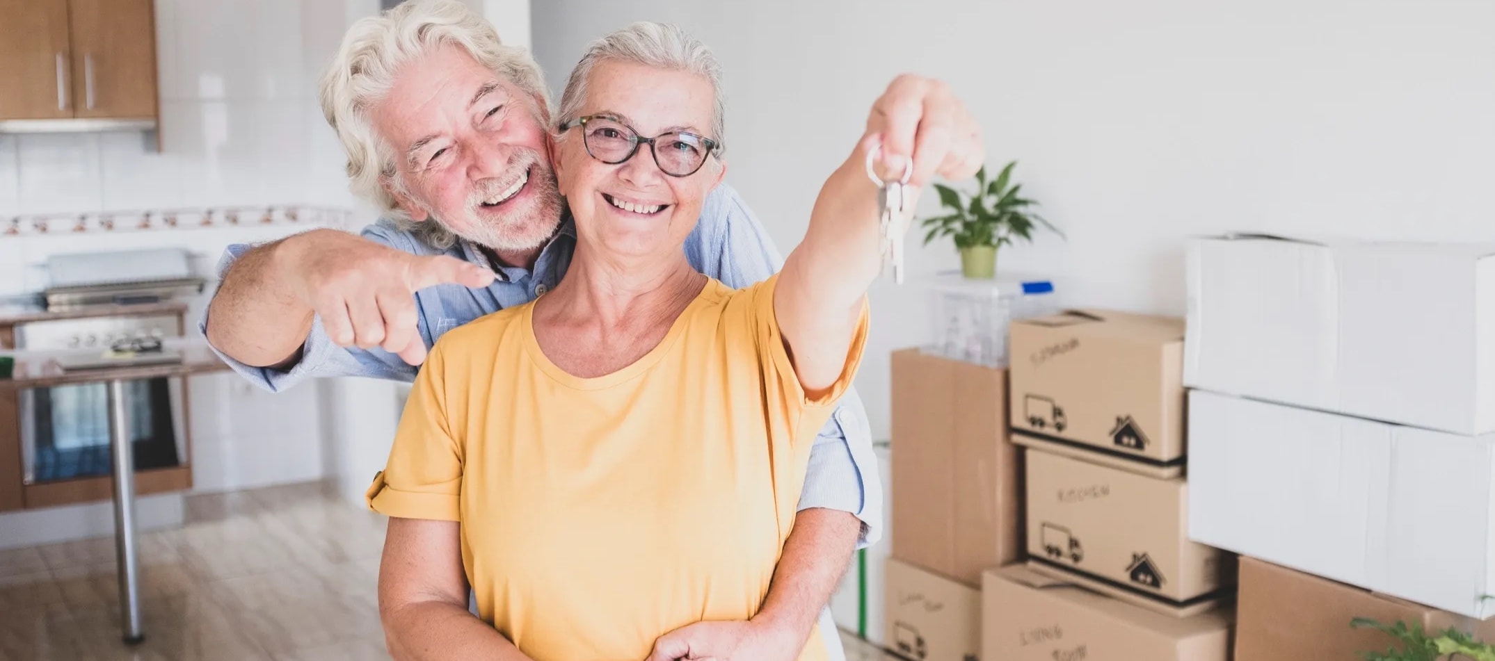 Happy senior couple with keys to their new home